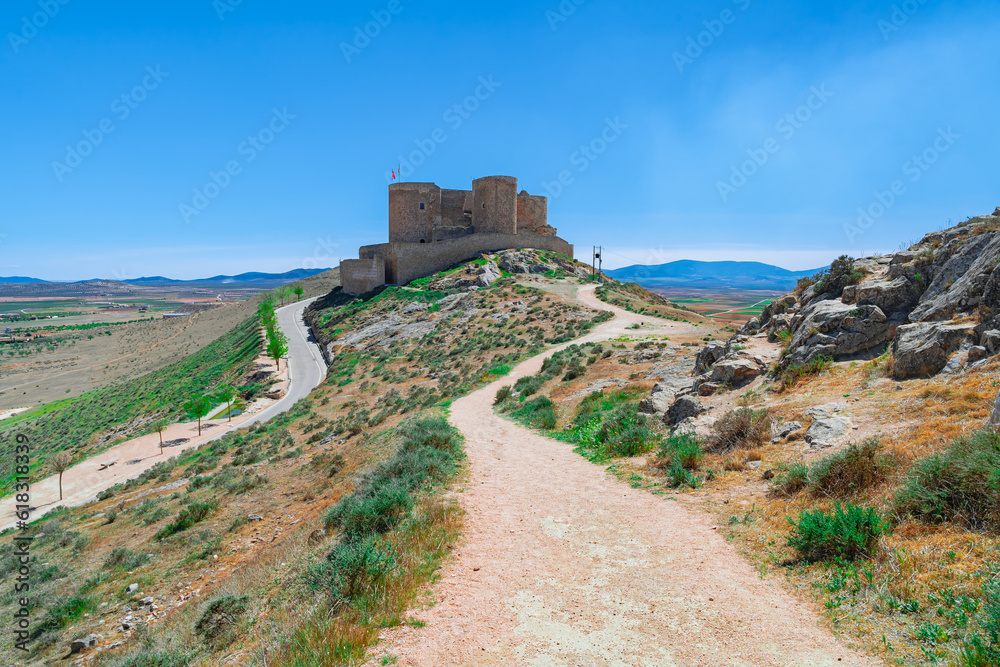 Castillo medieval en lo alto de una colina con caminos, desde Consuegra, Toledo, España.
