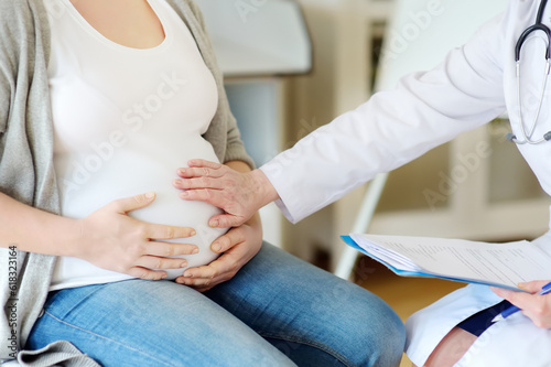 Gynecologist doctor accepts of a pregnant woman. Medical insurance childbearing. Family doctor for gestation. Maternity leave.