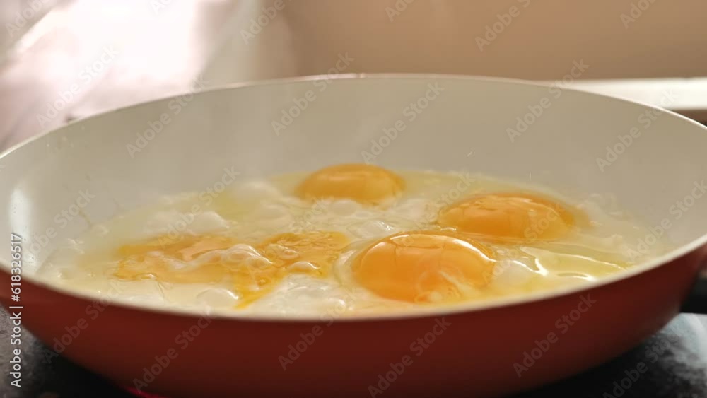 Frying pan with eggs in the morning sunlight.Fried eggs for breakfast.scrambled eggs. protein breakfast. bubbling scrambled eggs.process of preparing breakfast. 4k footage Frying pan with eggs in the morning sunlight.Fried eggs for breakfast.scrambled eggs. protein breakfast. bubbling scrambled eggs.process of preparing breakfast. 4k footage