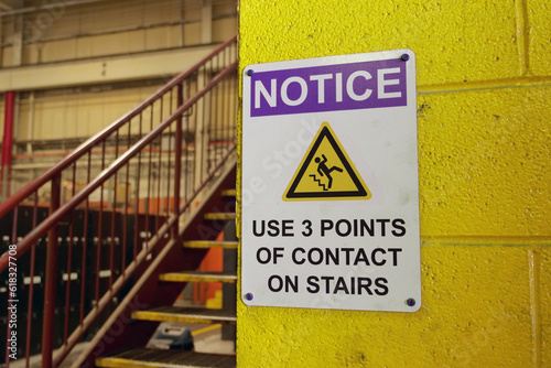 Caution sign near stairway in factory.