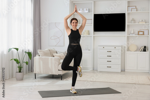 Happy woman doing morning exercise at home