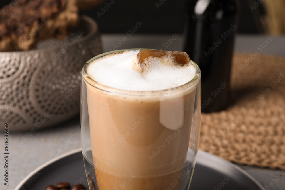 Glass of aromatic coffee with syrup on plate, closeup Glass of aromatic coffee with syrup on plate, closeup