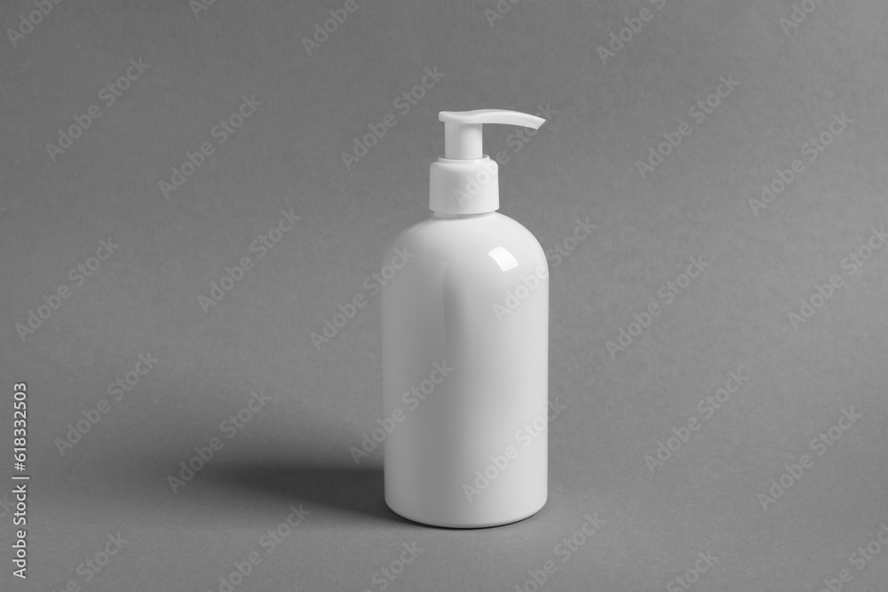 Bottle with cosmetic product on grey background Bottle with cosmetic product on grey background
