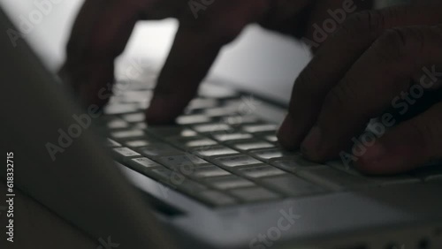 close up of fingers typing on silver laptop keyboard selective focus
