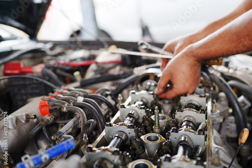 Auto mechanic repair engine in a car repair shop and Checking a car engine for repair at car garage.Car engine repair. Car service