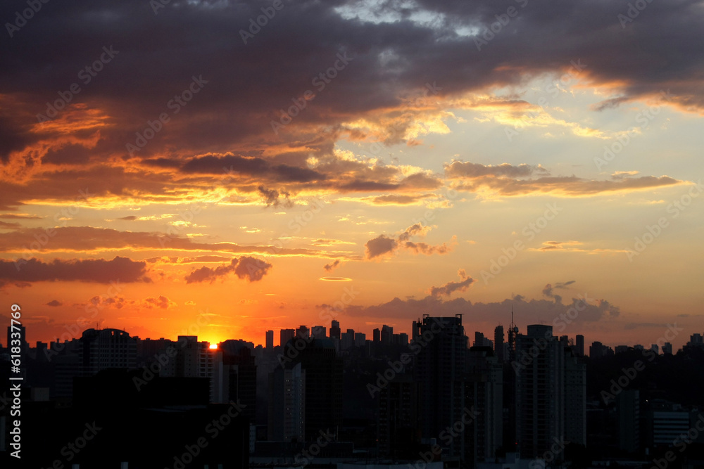 Um maravilhoso pôr do sol sobre a cidade de São Paulo, com nuvens coloridas pintando o cenário com encanto.