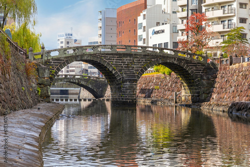 Nagasaki, Japan - Nov 29 2022: Meganebashi Bridge is the most remarkable of several stone bridges. The bridge gets its name from the resemblance of spectacles when reflected in the river water