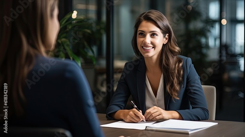 Smiling Female Manager Interviewing an Applicant In Office photo