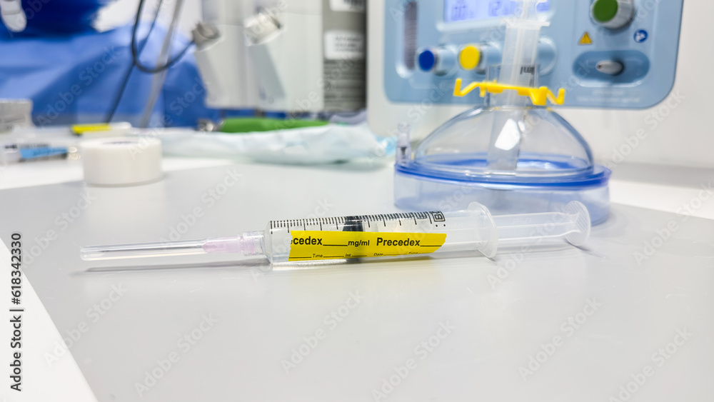 hand holds a syringe amidst IV drips and medications, symbolizing medical care, treatment, and the use of drugs in a hospital setting hand holds a syringe amidst IV drips and medications, symbolizing medical care, treatment, and the use of drugs in a hospital setting