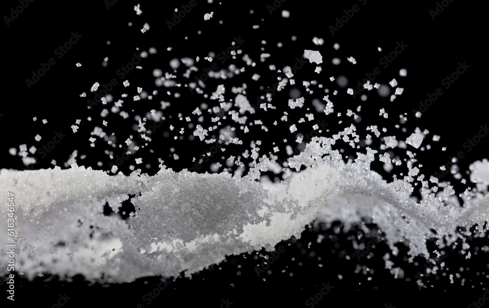 Salt powder pour fall in bowl, white Salt crystal cook abstract cloud fly. Ground salt splash in air, food object element design. Black background isolated selective focus blur