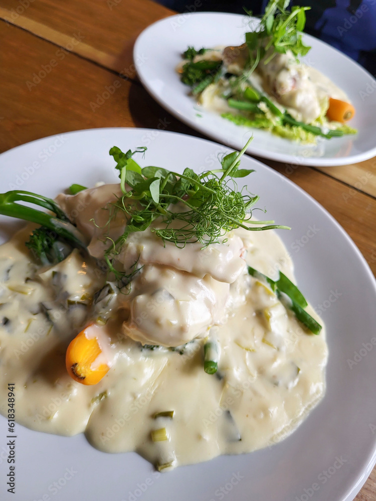 Pub lundh of chicken fillet wrapped in cured ham with a Welsh cheddar and leek sauce with seasonal vegetables. Pub lundh of chicken fillet wrapped in cured ham with a Welsh cheddar and leek sauce with seasonal vegetables.