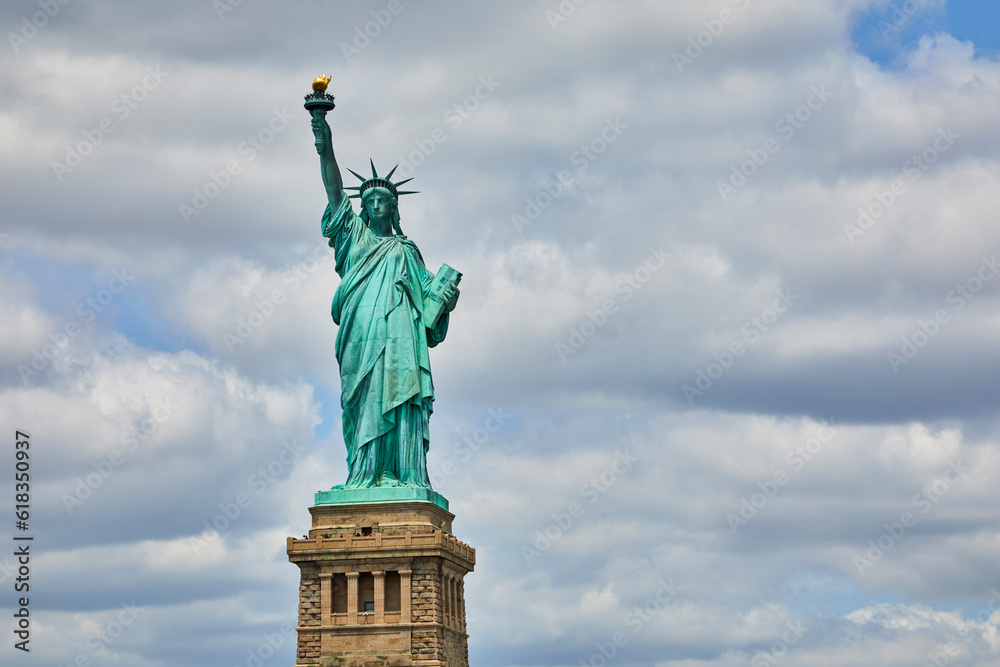 Statue of Liberty close up image against a beautiful cloudy sky on a summer day