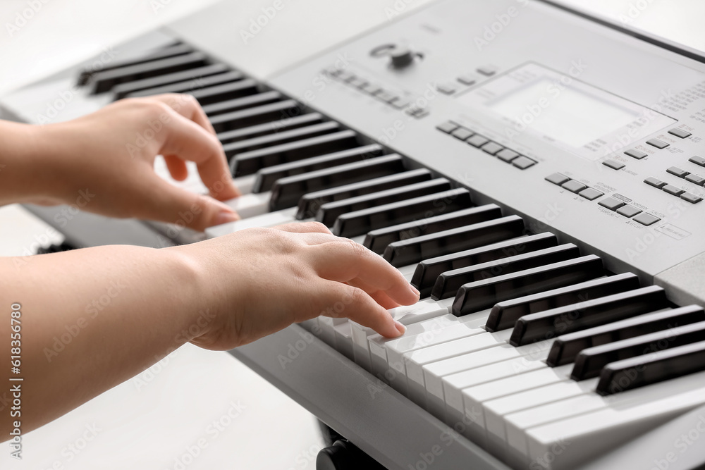 Fototapeta premium Woman playing modern synthesizer, closeup