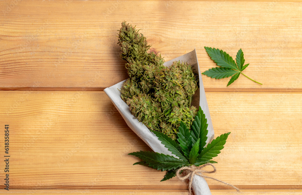 A bouquet of marijuana with a leaf on wooden planks. A bouquet of marijuana with a leaf on wooden planks.