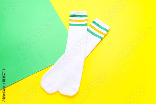 Pair of soft cotton socks on color background