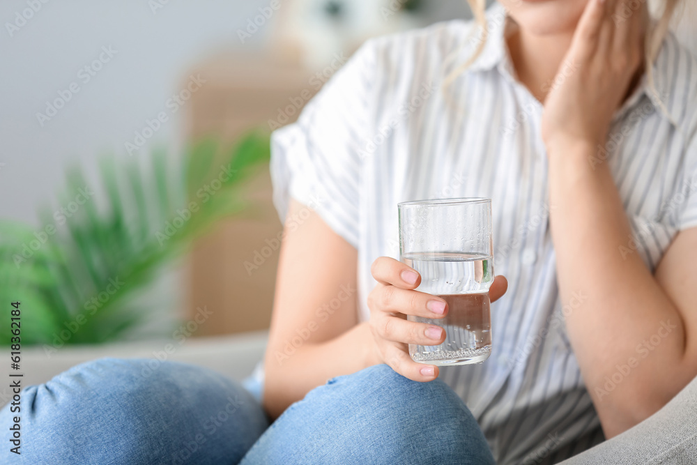 Young woman with dissolved tablet in glass of water at home, closeup Young woman with dissolved tablet in glass of water at home, closeup