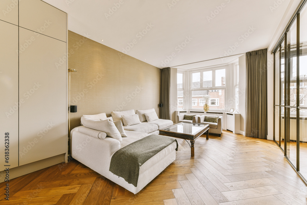 a living room with wood flooring and white couches in the room is very spacious, but it's not too a living room with wood flooring and white couches in the room is very spacious, but it's not too