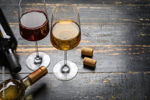 Slika na platnu Glasses of exquisite wine on dark wooden background