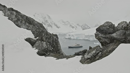 Big expedition ship or boat sitting in a bay in Antarctica, dolly shot photo