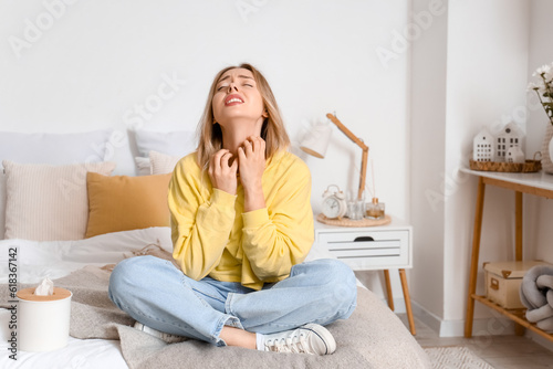 Foto Allergic young woman scratching in bedroom