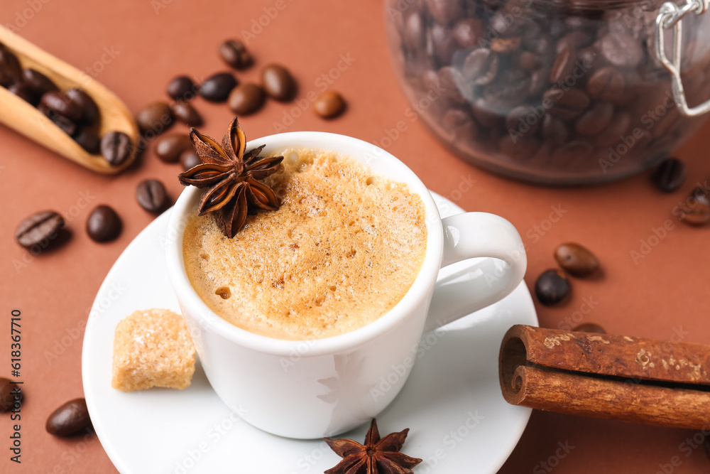 Cup of hot espresso and jar with coffee beans on brown background Cup of hot espresso and jar with coffee beans on brown background