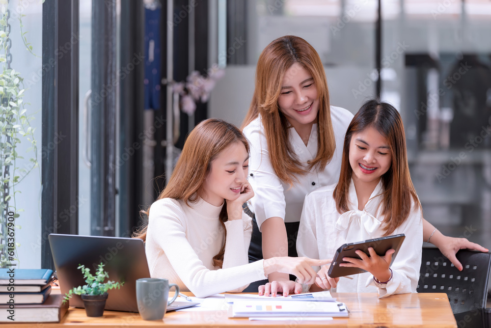 Three young Asian businesswomen discussing a new Idea Presentation business project In Modern Office. Three young Asian businesswomen discussing a new Idea Presentation business project In Modern Office.