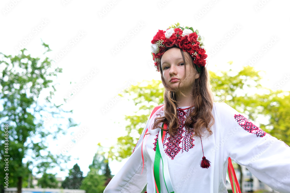 cute young girl teenager ukrainian woman in folk traditional image fixing her hair. the wind blows and develops her curls beautiful wreath with many flowers ribbons nature female natural beauty folk cute young girl teenager ukrainian woman in folk traditional image fixing her hair. the wind blows and develops her curls beautiful wreath with many flowers ribbons nature female natural beauty folk
