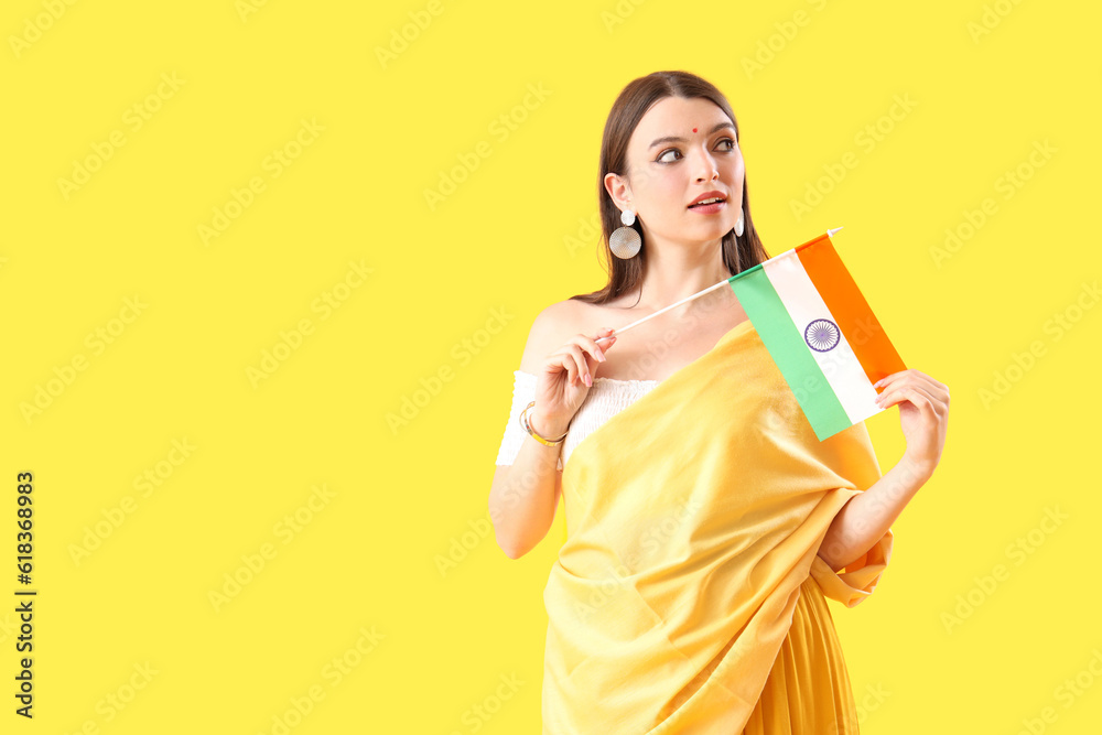 Young woman with Indian flag on yellow background Young woman with Indian flag on yellow background