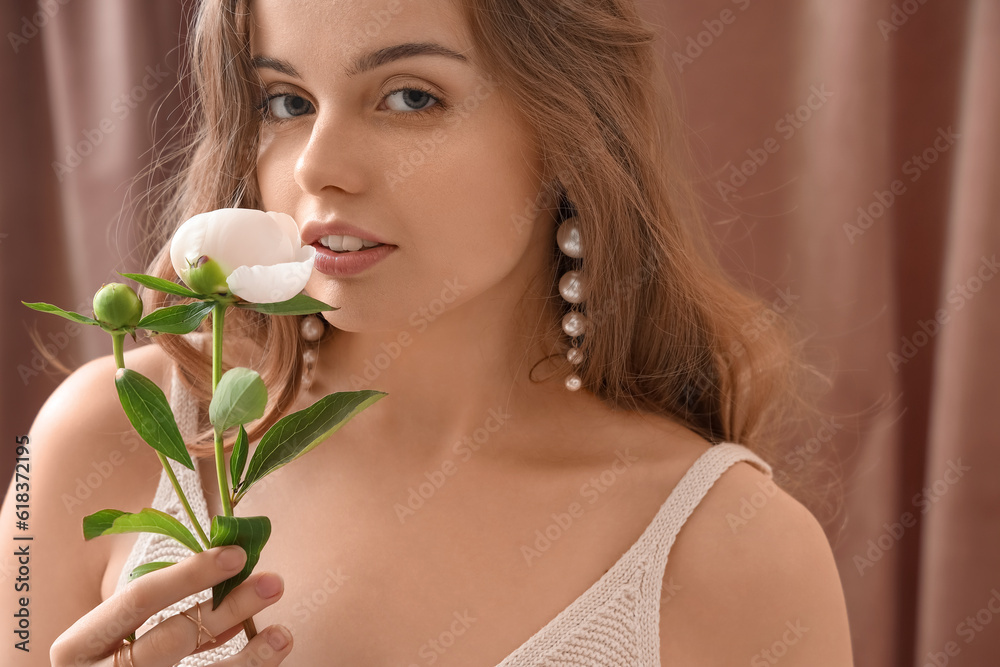 Beautiful young woman with peony flower, closeup