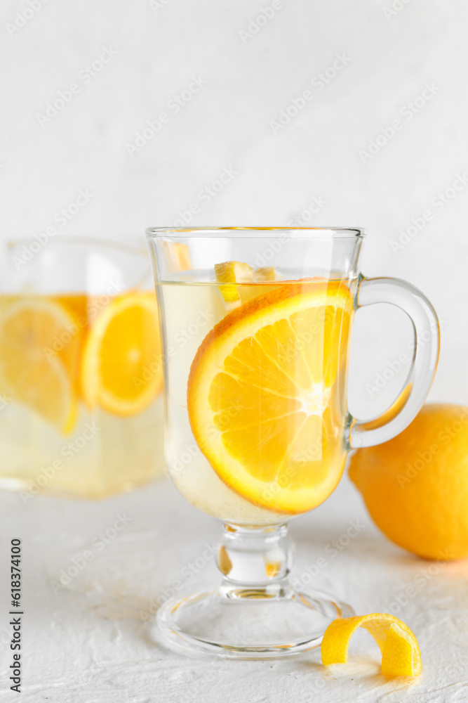 Glass cup of infused water with lemon on light background Glass cup of infused water with lemon on light background