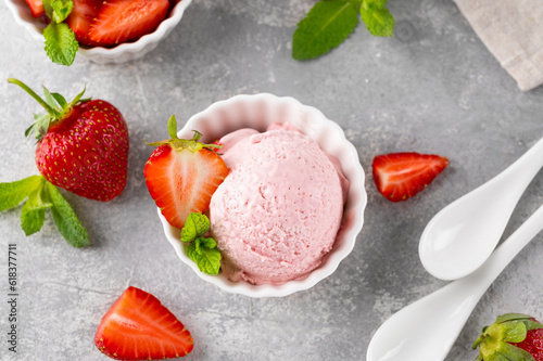 Strawberry ice cream with fresh berries in a bowl on a gray concrete background. Selective focus