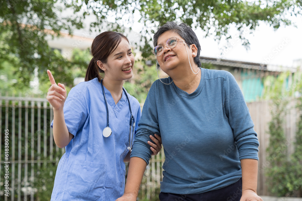 Nurse and patient Asian elderly woman with walker. Nurse caring older woman walking with walker outdoor at hospital. Asian nurse taking care old woman with walker in garden at home Nurse and patient Asian elderly woman with walker. Nurse caring older woman walking with walker outdoor at hospital. Asian nurse taking care old woman with walker in garden at home
