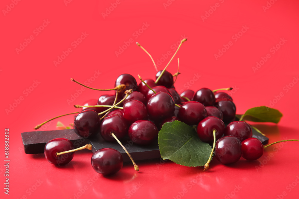 Board with sweet cherries on red background Board with sweet cherries on red background