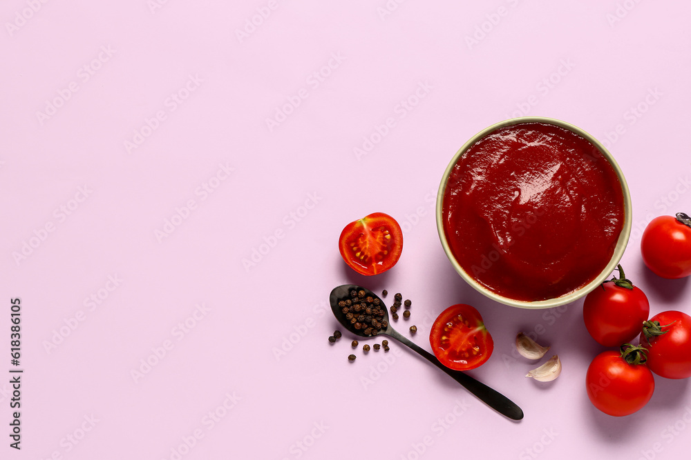 Bowl with tomato paste and fresh vegetables on lilac background Bowl with tomato paste and fresh vegetables on lilac background