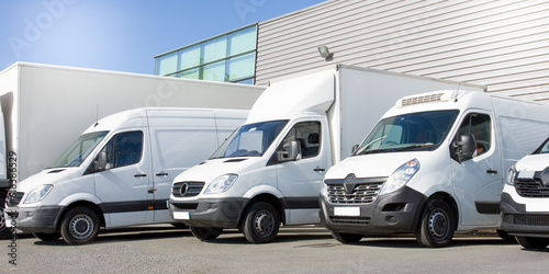 Billede på lærred delivery white vans in service van fleet of cargo trucks courier and cars in fro