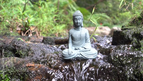 Buddha statue on the background of a forest stream, water flows over the stone.
Mini fountain for relaxation, meditation.