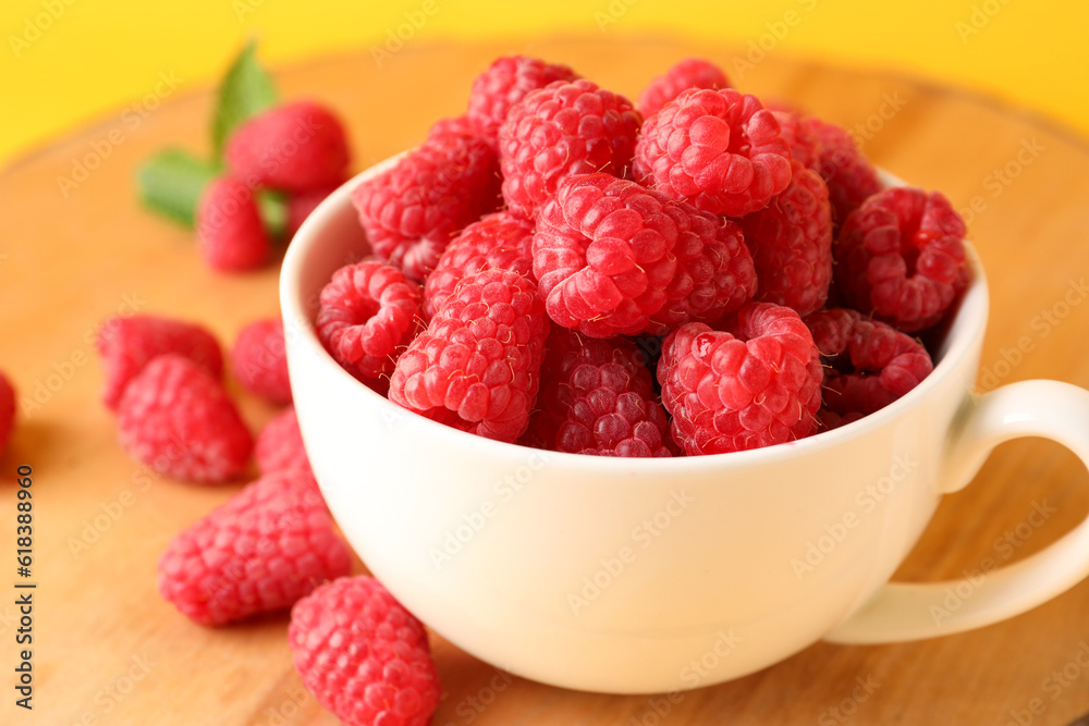 Cup and board with fresh raspberries, closeup Cup and board with fresh raspberries, closeup