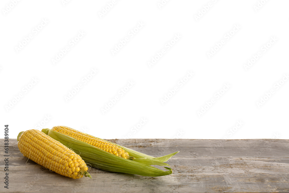 Fresh corn cobs on grey wooden table against white background