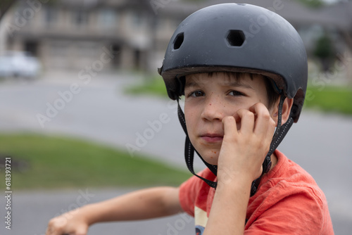 Young boy on bike looks towards camera with helmet on