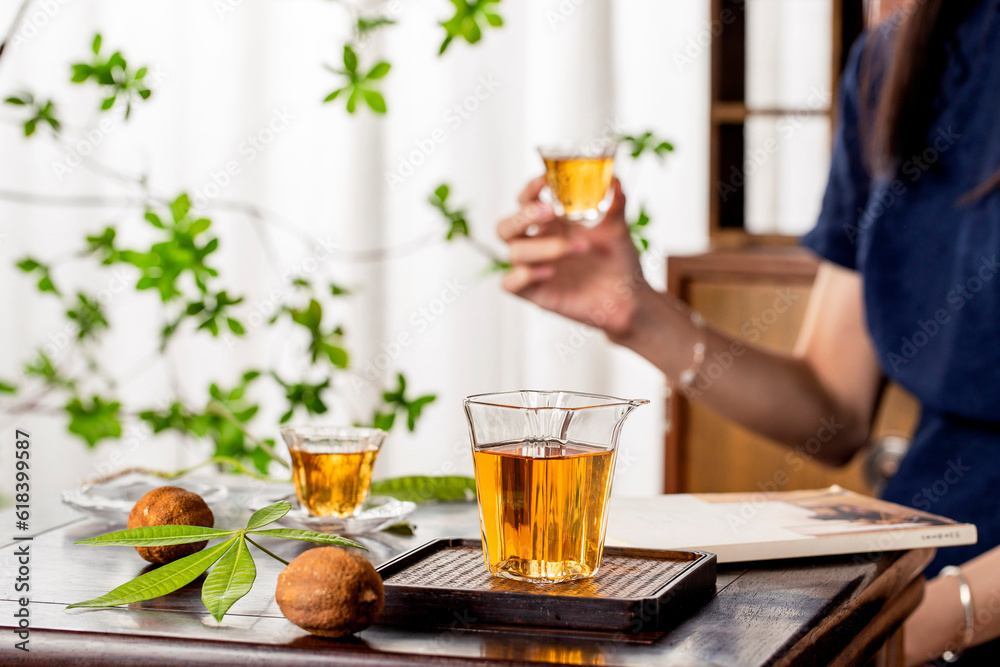 Scene with oriental woman drinking tea, tea in a glass teacup, traditional tea set, oriental style interior scene Scene with oriental woman drinking tea, tea in a glass teacup, traditional tea set, oriental style interior scene