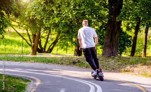 Wallpaper Mural A guy rides an electric scooter in the summer Park

 Torontodigital.ca