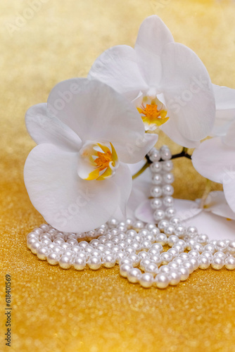 A branch of white orchids on a shiny gold background

