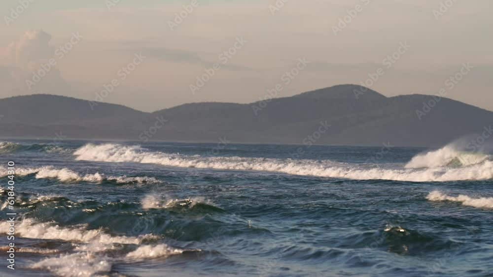 waves breaking in the sand of a beach in australia waves breaking in the sand of a beach in australia