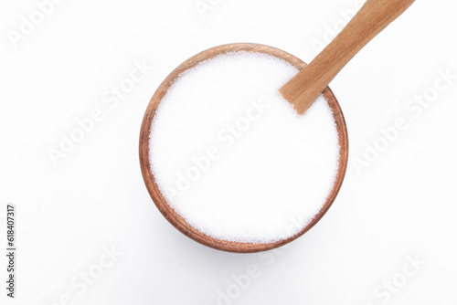 Sól spożywcza w drewnianej okrągłej miseczce z łyżeczką na białym tle