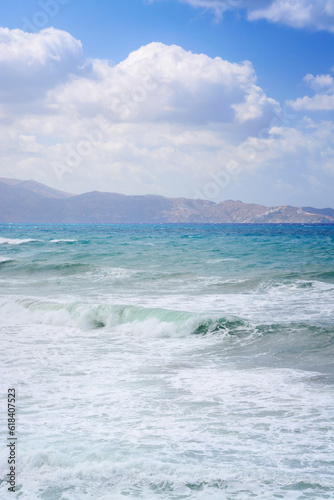 Sea view with wave, hills in the distance and cloudy sky in Crete