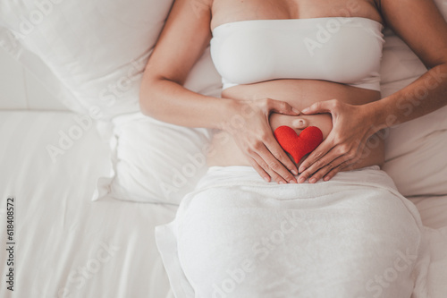Concept Motherhood and Pregnant, happy expectant mother during pregnancy, love mother waiting for baby. Pregnant woman holding palm symbol in heart shape.