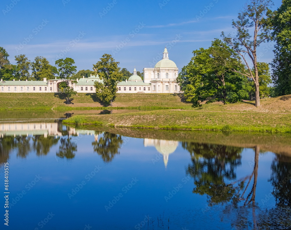 Fototapeta premium Morning in Oranienbaum park. Reflection of trees and sky in the lake.