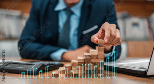 Plan and strategy in business. Business development and growth concepts. Businessman hand pulling out or placing wood block on the tower and semi-pyramid in modern office.