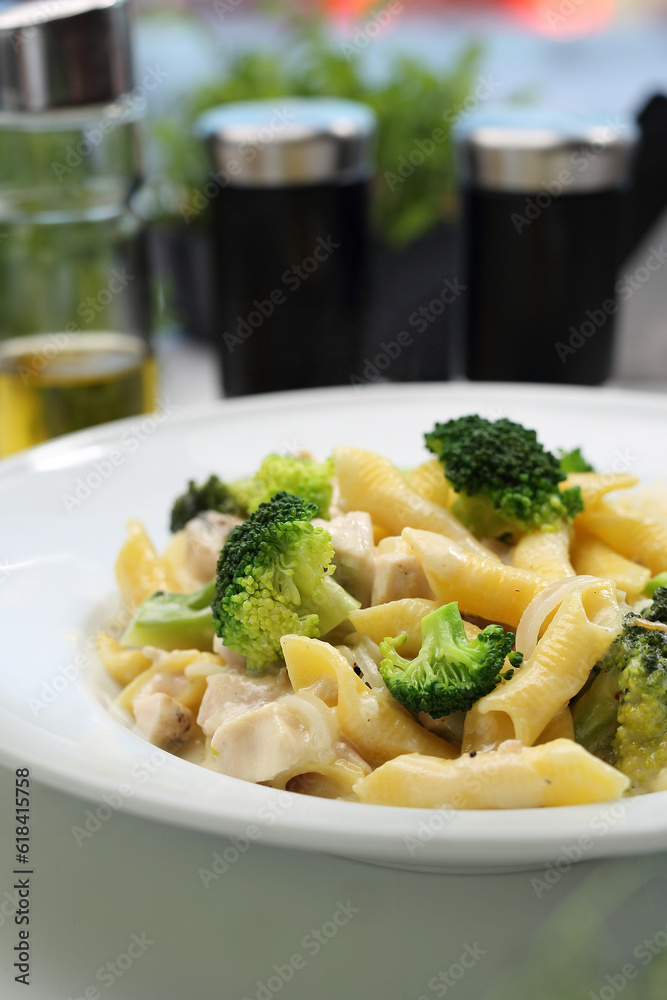 Cream penne pasta with broccoli, cream and cheese. Italy dish with chicken. Mediterranean cuisine, selective focus. Cream penne pasta with broccoli, cream and cheese. Italy dish with chicken. Mediterranean cuisine, selective focus.