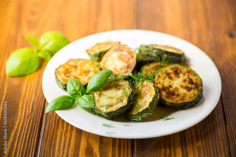 zucchini fried in circles with spices and herbs, in a plate . zucchini fried in circles with spices and herbs, in a plate .